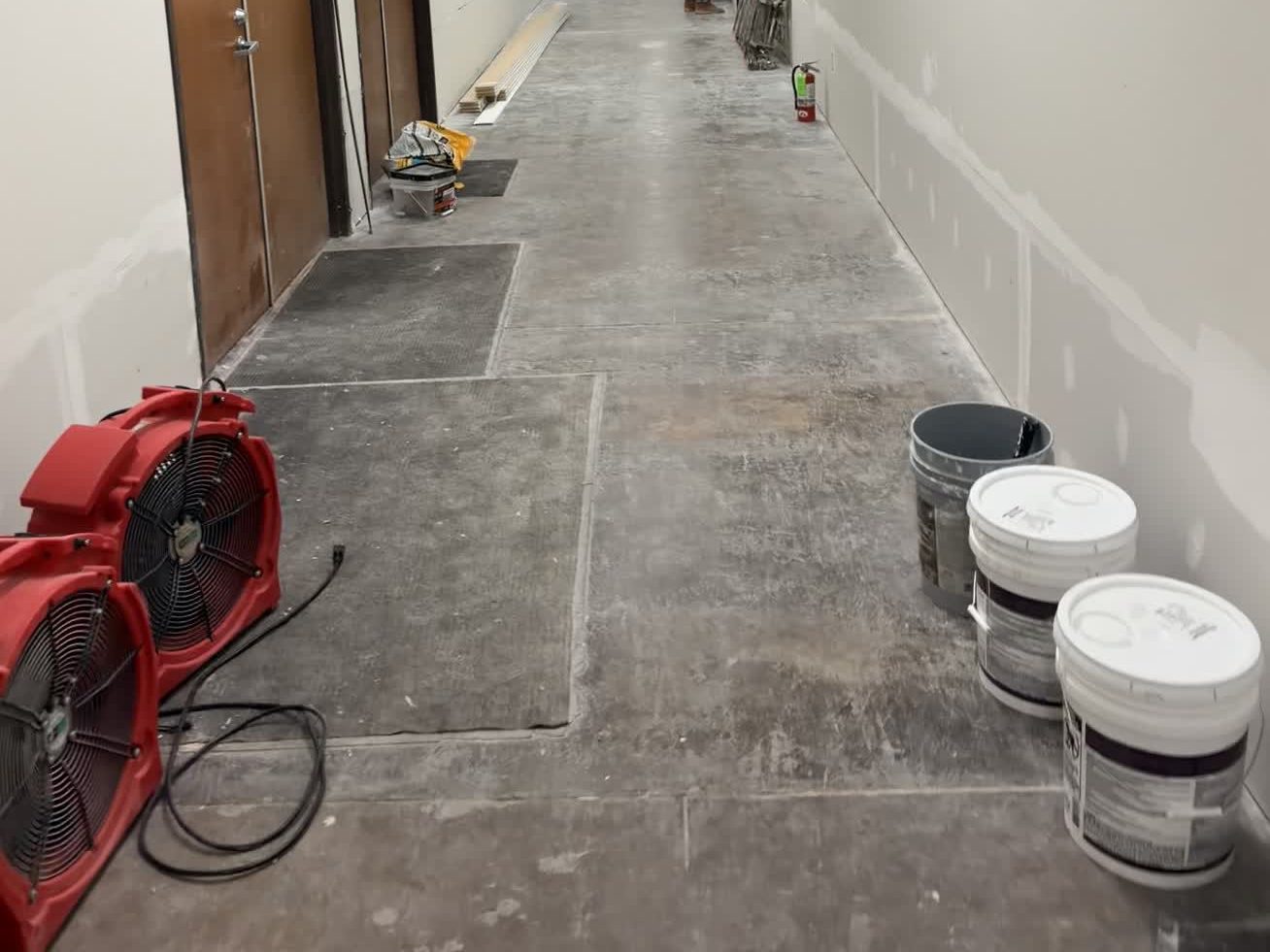 Air movers drying a corridor after a water loss