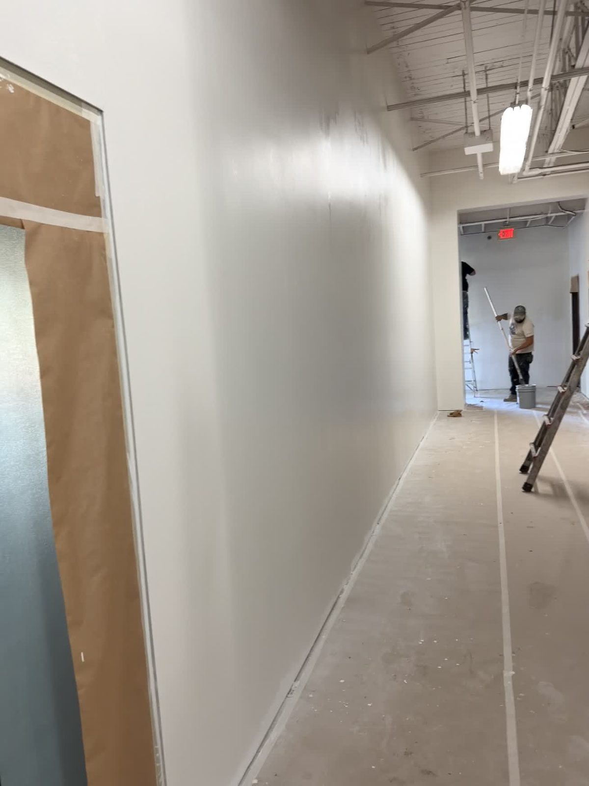 New drywall hung and finished along a commercial corridor