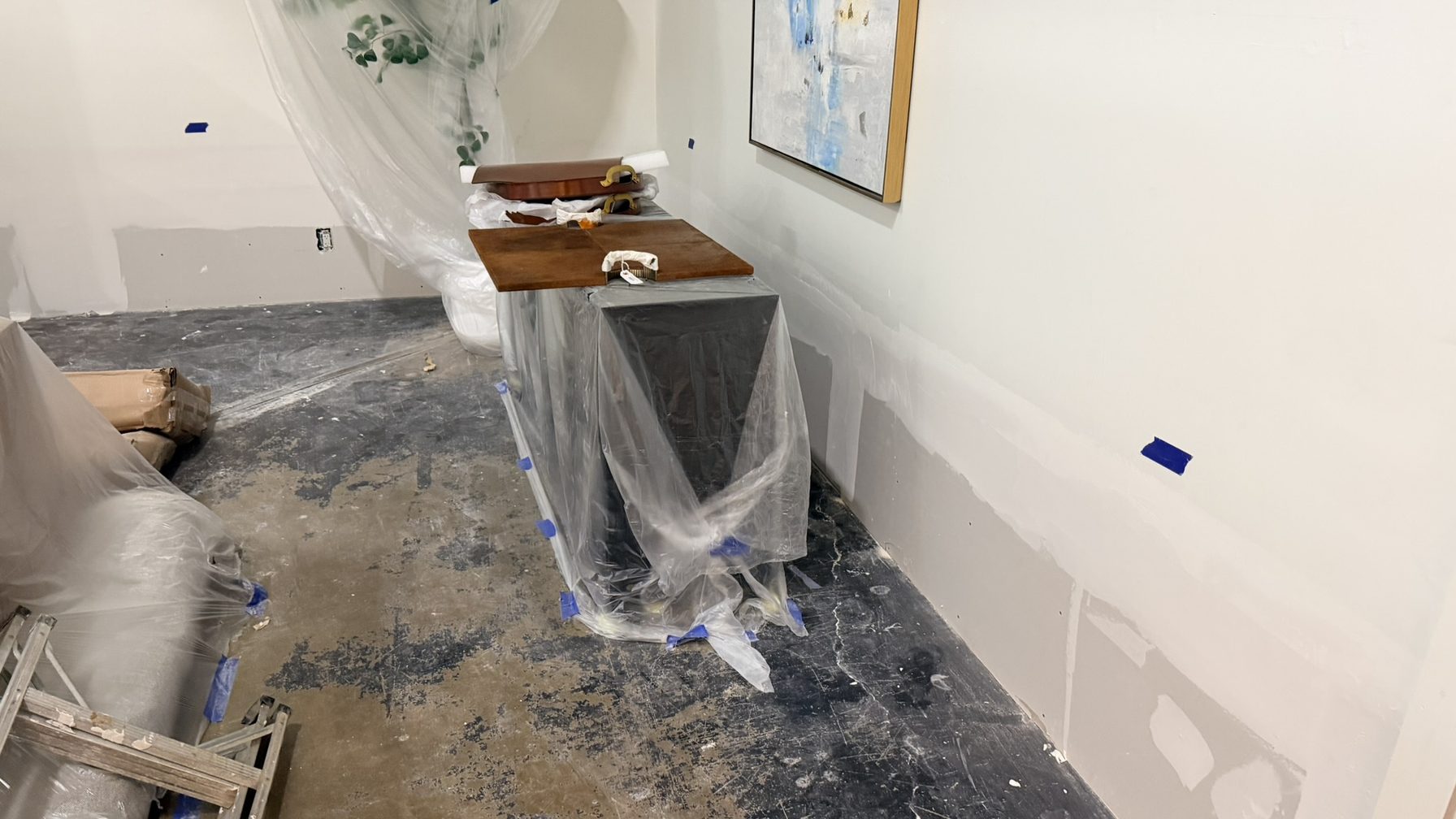 Furniture protected under plastic during a commercial repair