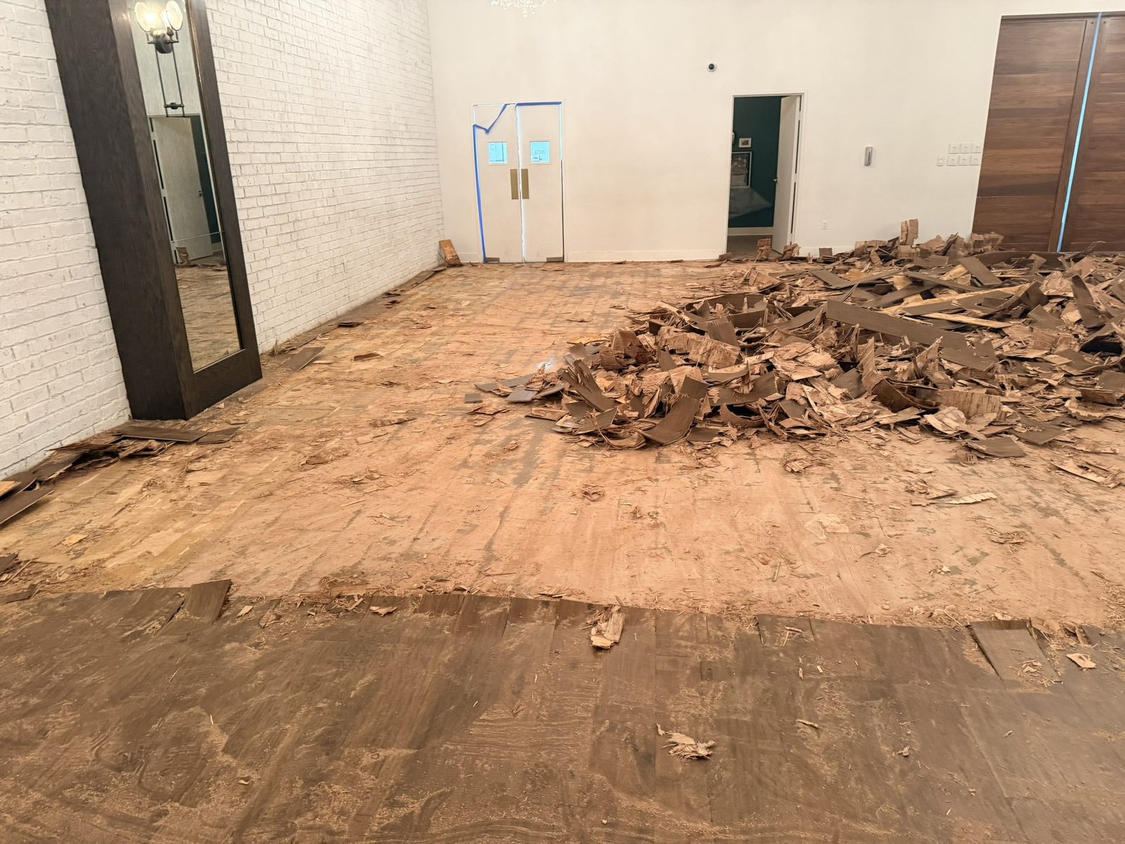 Failed hardwood torn out across a commercial suite