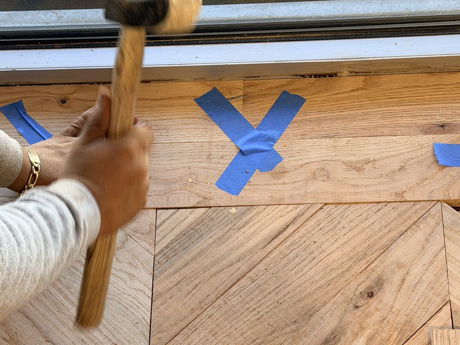 Mallet seating a chevron plank during the rebuild