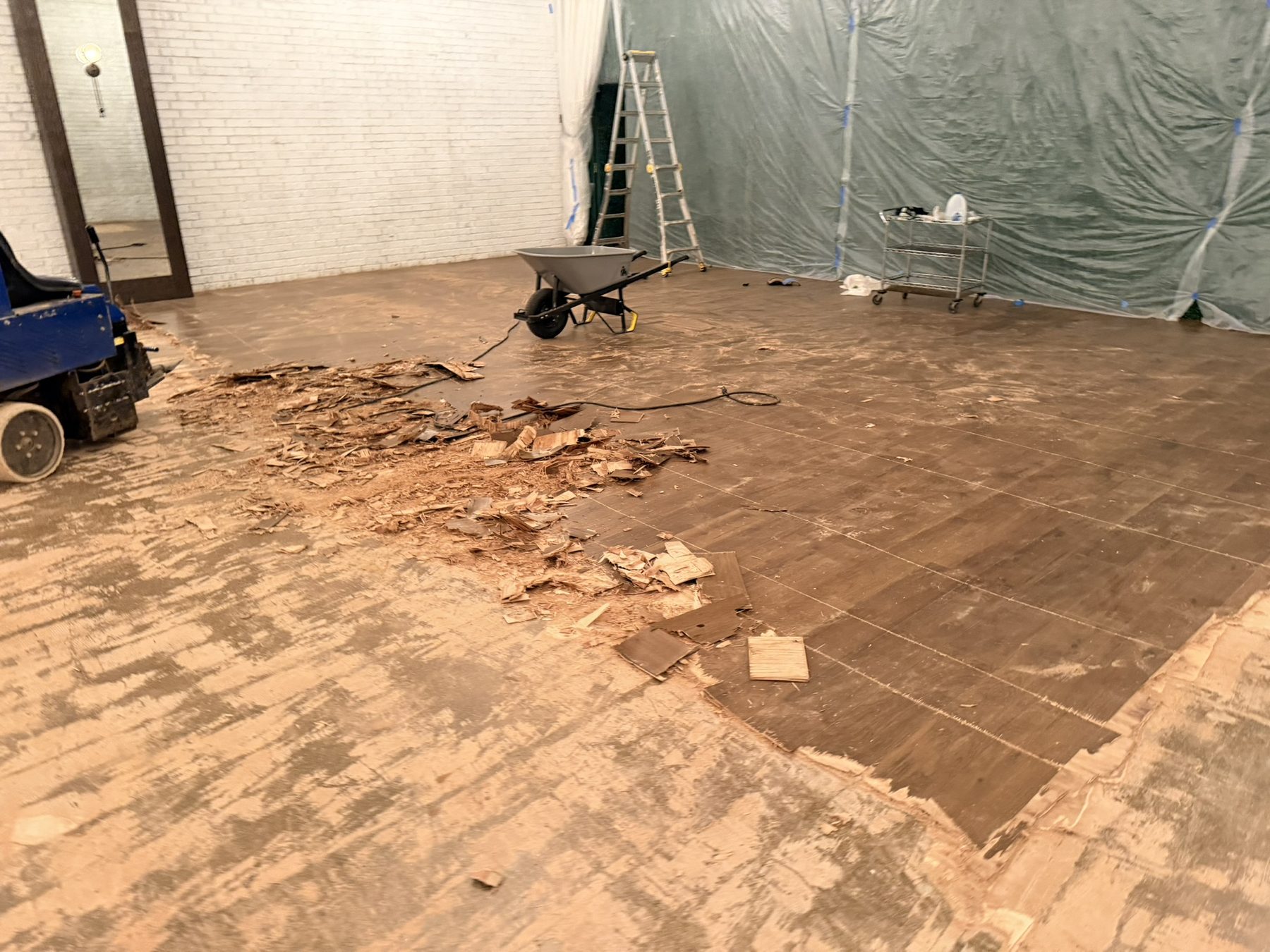 Ride-on scraper and pulled hardwood in a commercial suite